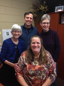 Millie is with Foster, Lori, and Susan in Susan's office at OMS Headquarters.